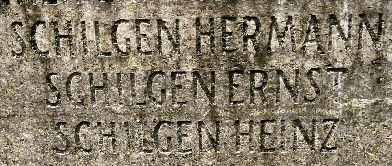 Nahaufnahme der Inschrift auf der Rückseite des Denkmals mit den drei untereinander eingemeißelten Namen Schilgen Hermann, Schilgen Ernst und Schilgen Heinz