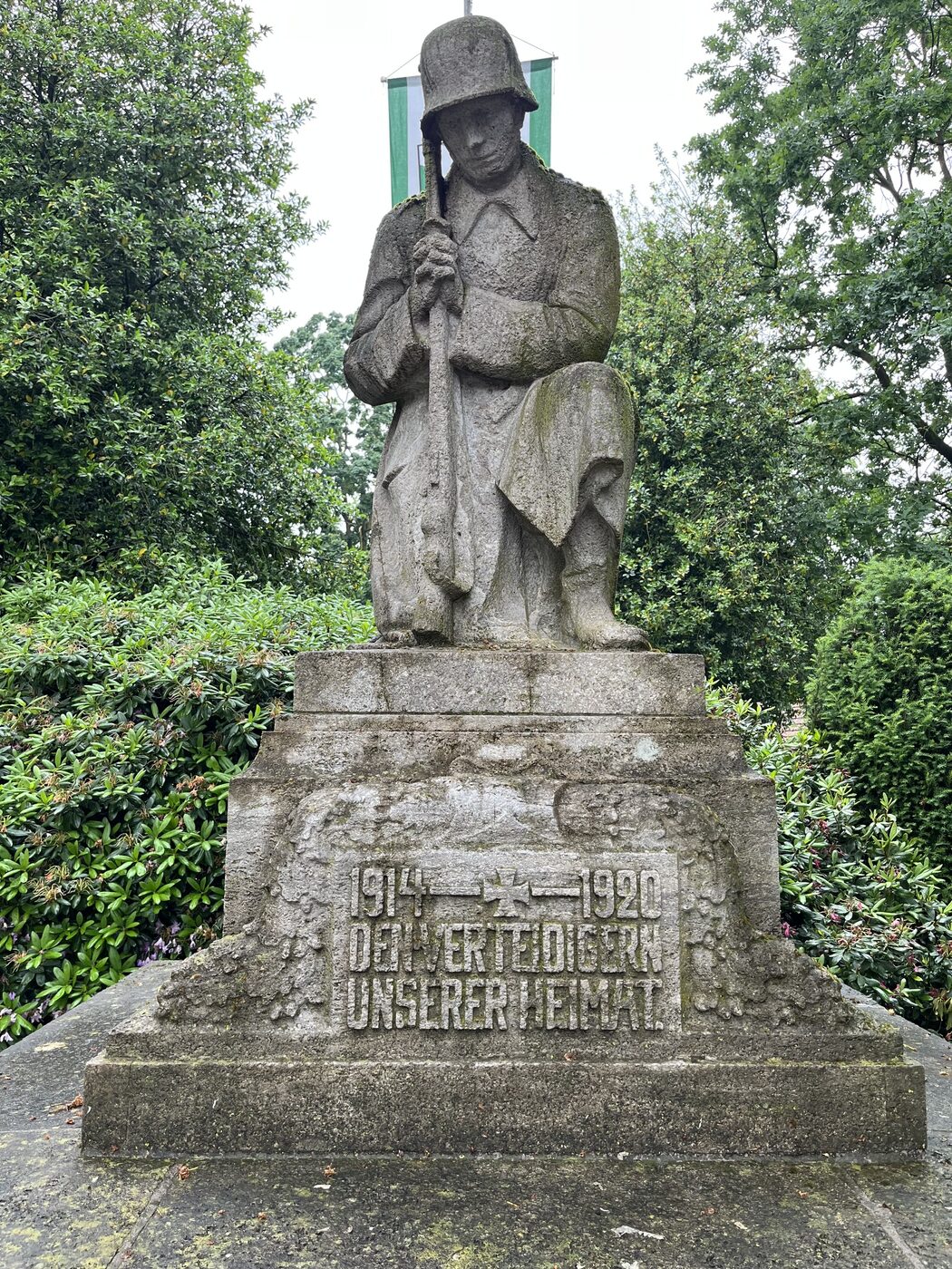 Kriegerdenkmal auf dem alten Friedhof Heidberge in Emsdetten — eine steinerne Soldatenfigur mit Stahlhelm auf hohem Sockel, Inschrift 1914 bis 1920, Den Verteidigern unserer Heimat