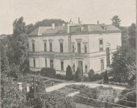 Zweigeschossige weiße Villa mit gepflegtem Vorgarten und Hecken, Schwarzweißfotografie